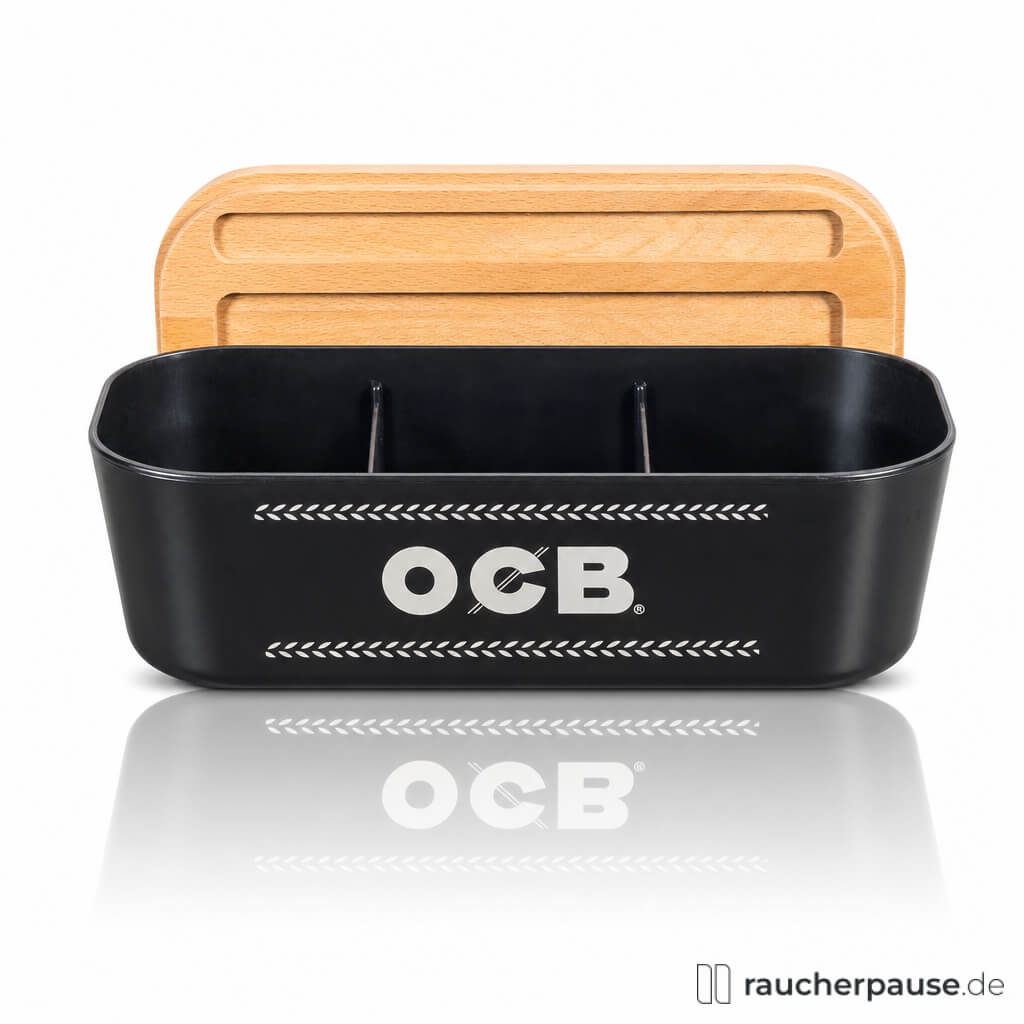 OCB Rolling Box mit Tray: schwarze Dose mit weißem Logo und Holzdeckel auf rechteckiger Oberfläche