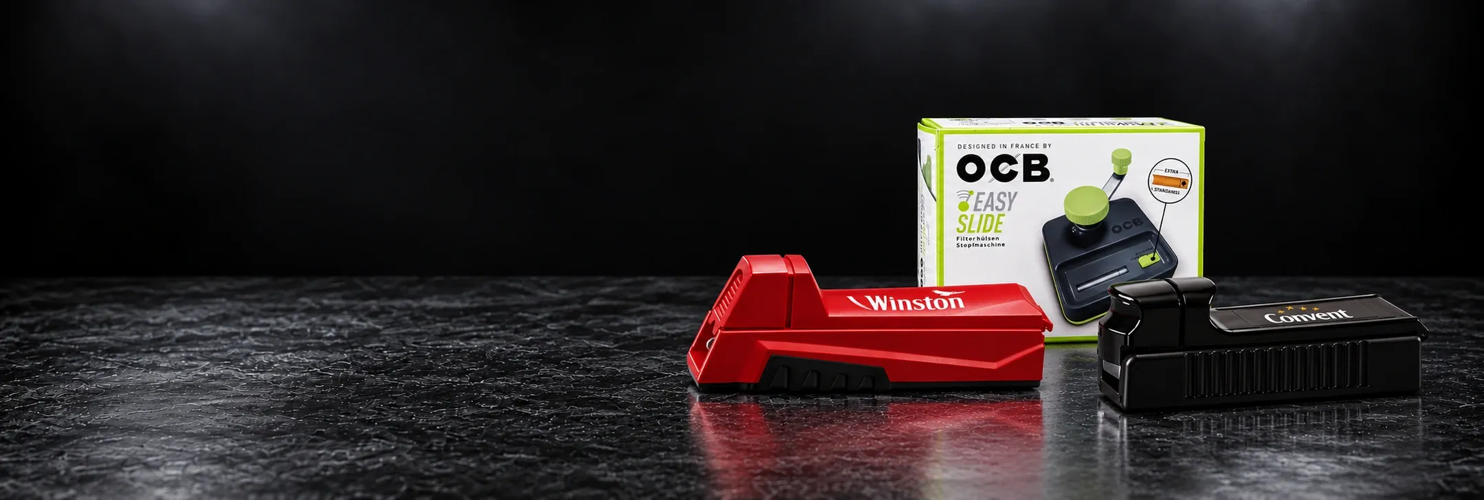 Manuelle Stopfgeräte von Winston und Convent sowie eine Verpackung des OCB Easy Slide auf dunklem Hintergrund